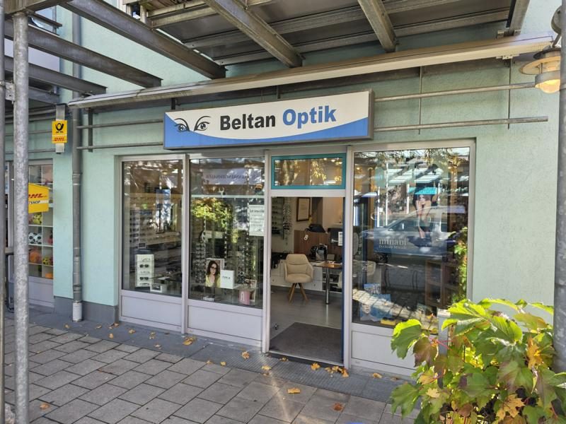 Ladenfront von Beltan Optik in der Karwinskistraße 52 in Obermenzing: mintgrüne Fassade, Schaufenster und das Ladenschild „Beltan Optik“