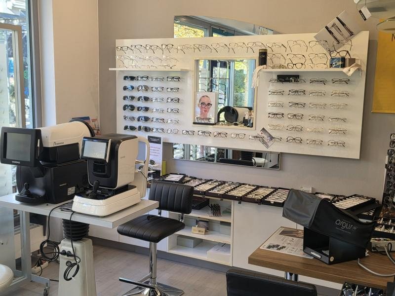 Blick in den Laden von Beltan Optik: Brillenwand mit Fassungen, moderne Messgeräte von Rodenstock und Beratungsplatz