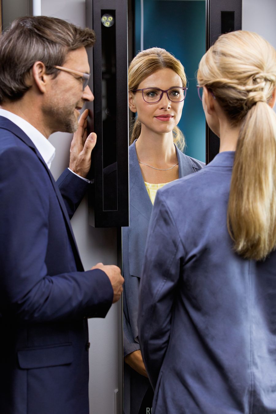 Videoberatung am Rodenstock ImpressionIST: Kundin probiert eine Brille vor dem Beratungsspiegel, der Optiker berät